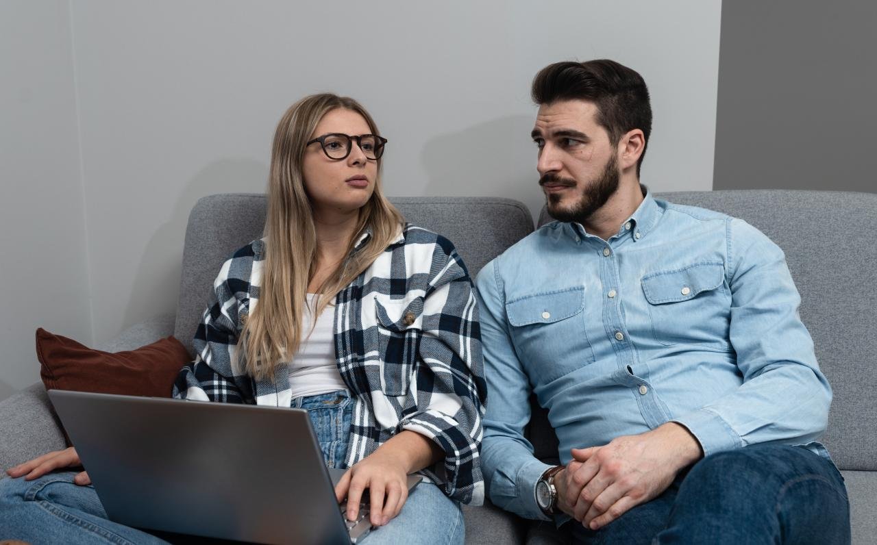 A couple is pictured sitting together while planning the guest list for wedding invitations | Source: Shutterstock