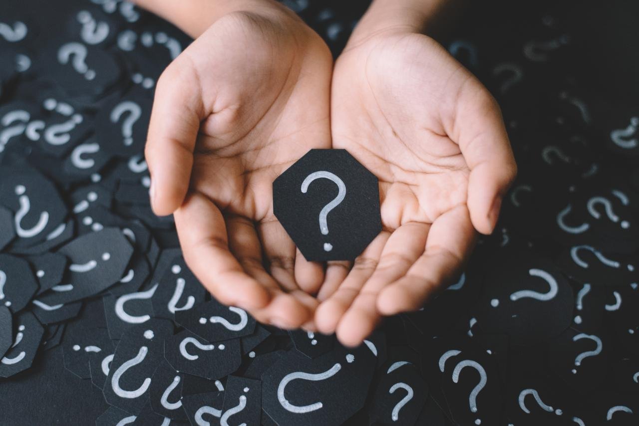 Two hands holding a question mark sign | Source: Shutterstock